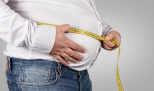 Overweight Man Measuring His Belly with tape measure