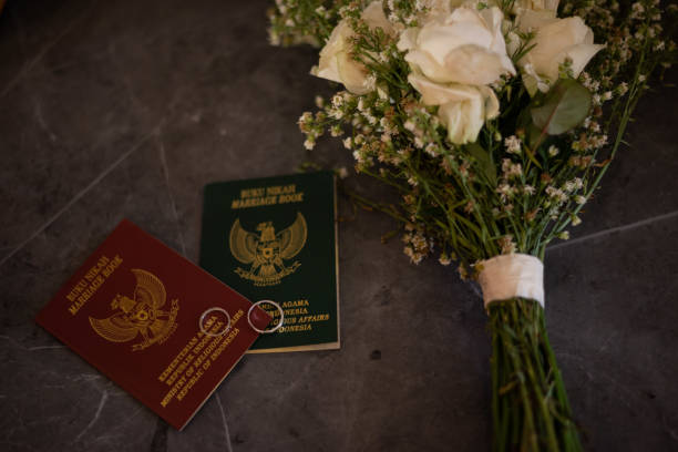a pair of wedding books and a bunch of flowers on the wedding table